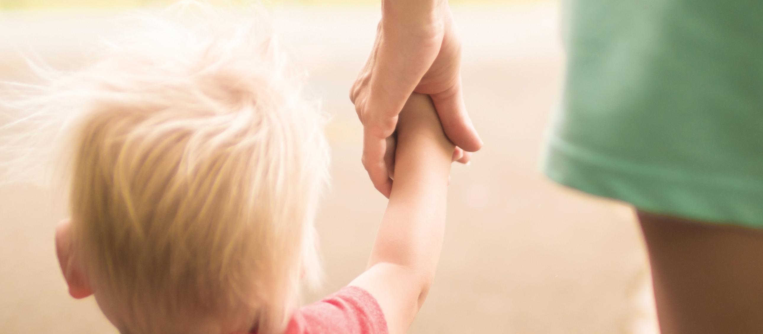 Boy holding hands with woman