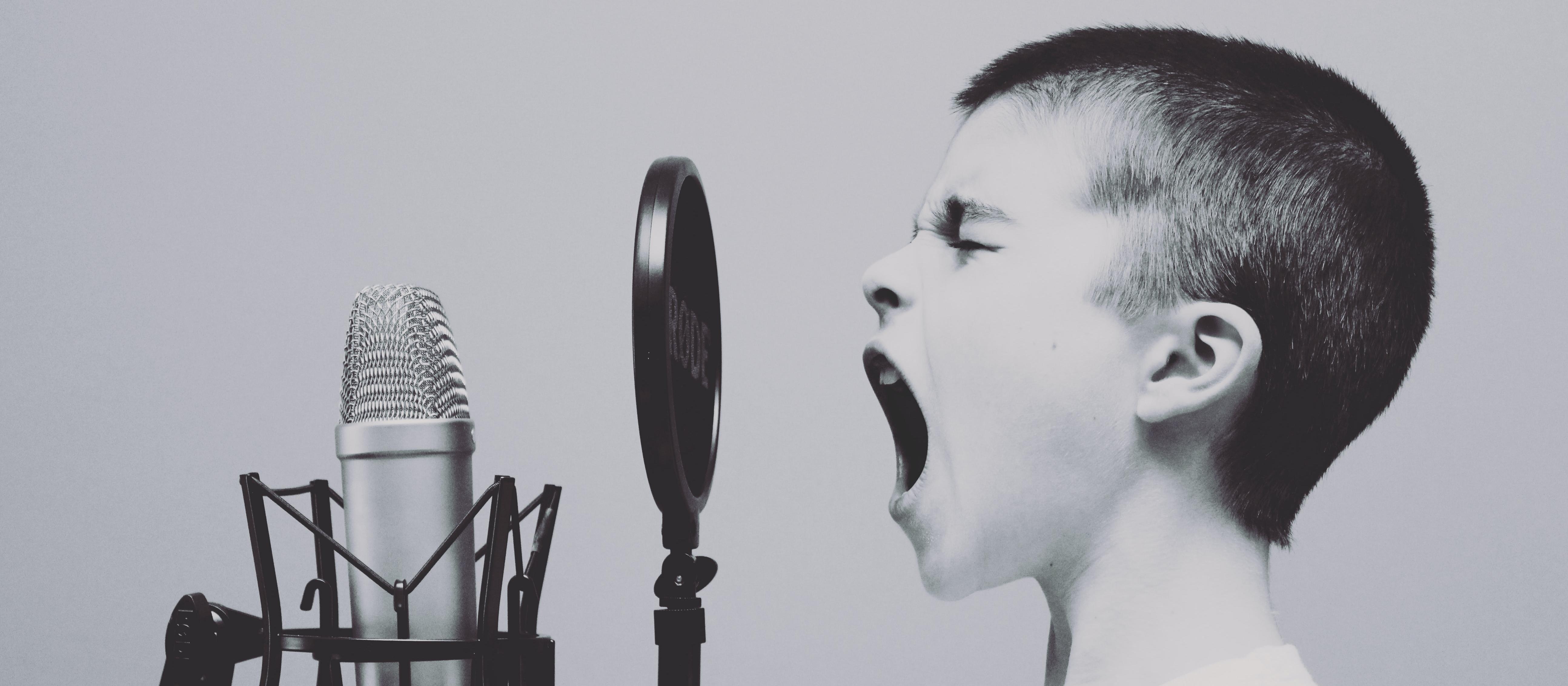 Kid speaking into microphone, microphone, Unsplash Jason Rosewell