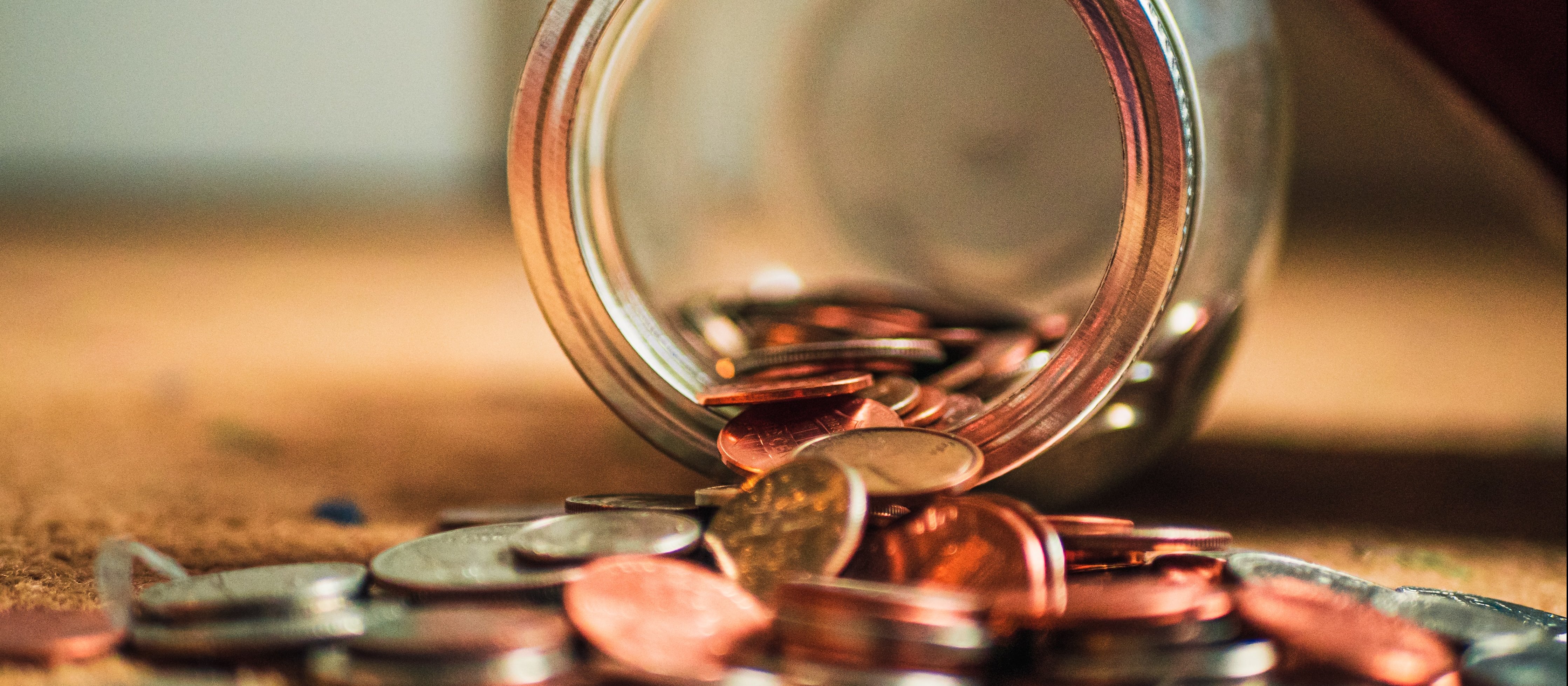 Coins spilling out of a clear jar