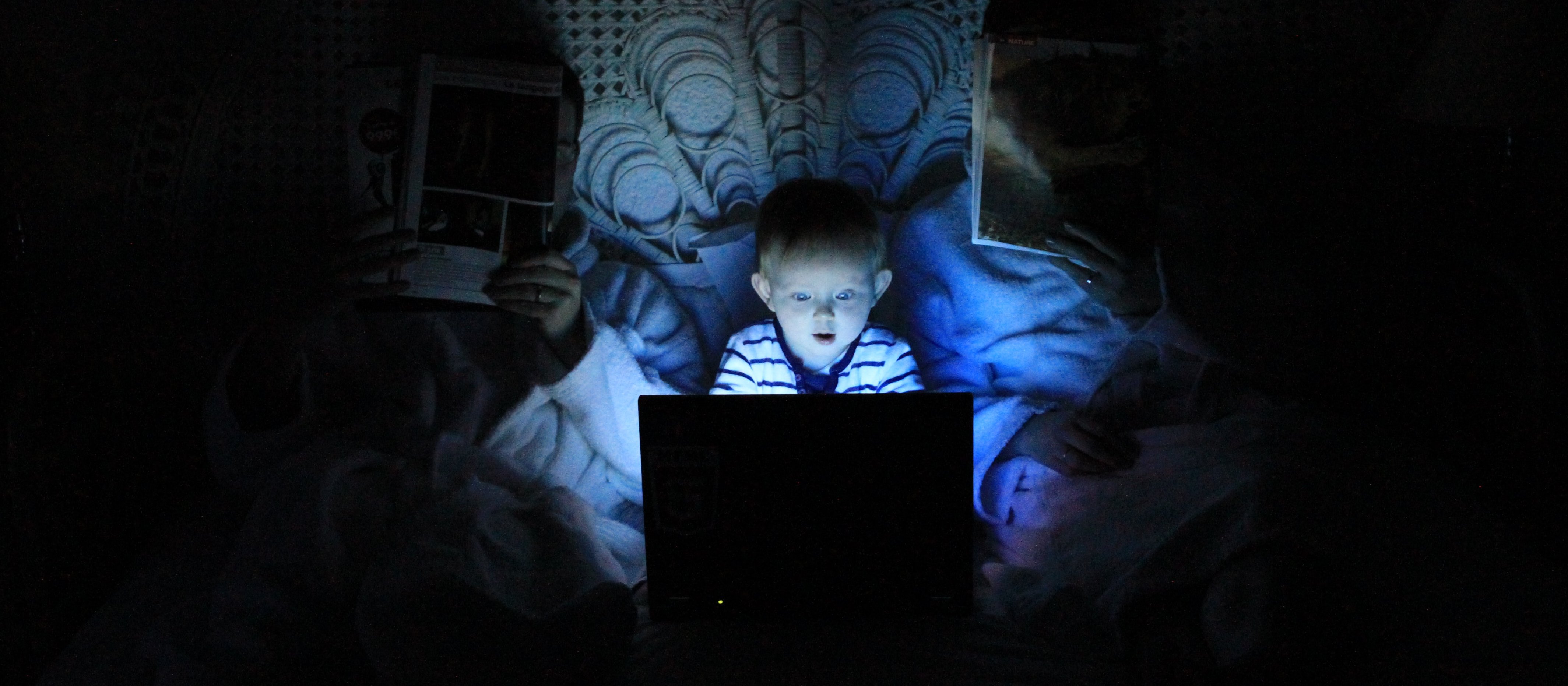 Child on bright screen in darkened room