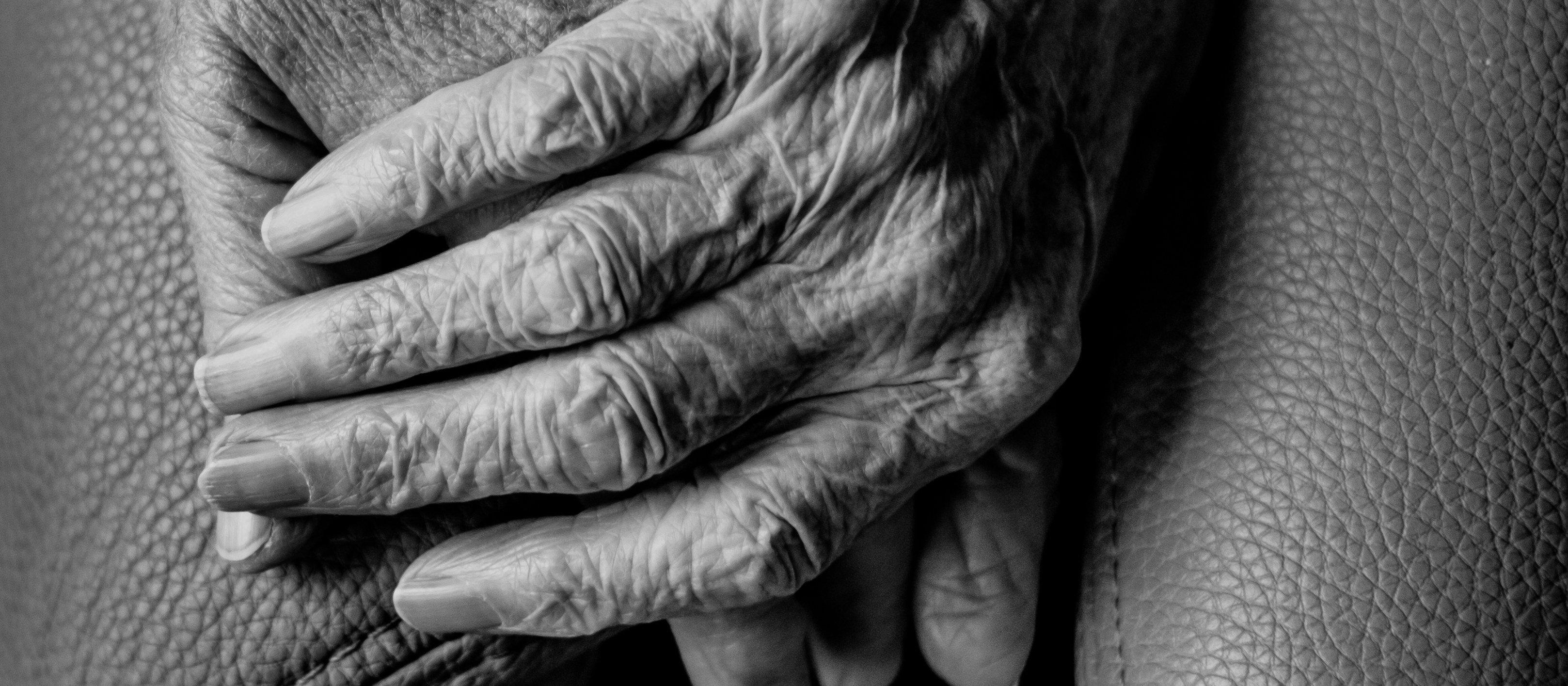 black and white image, close-up of hands of two old people holding hands