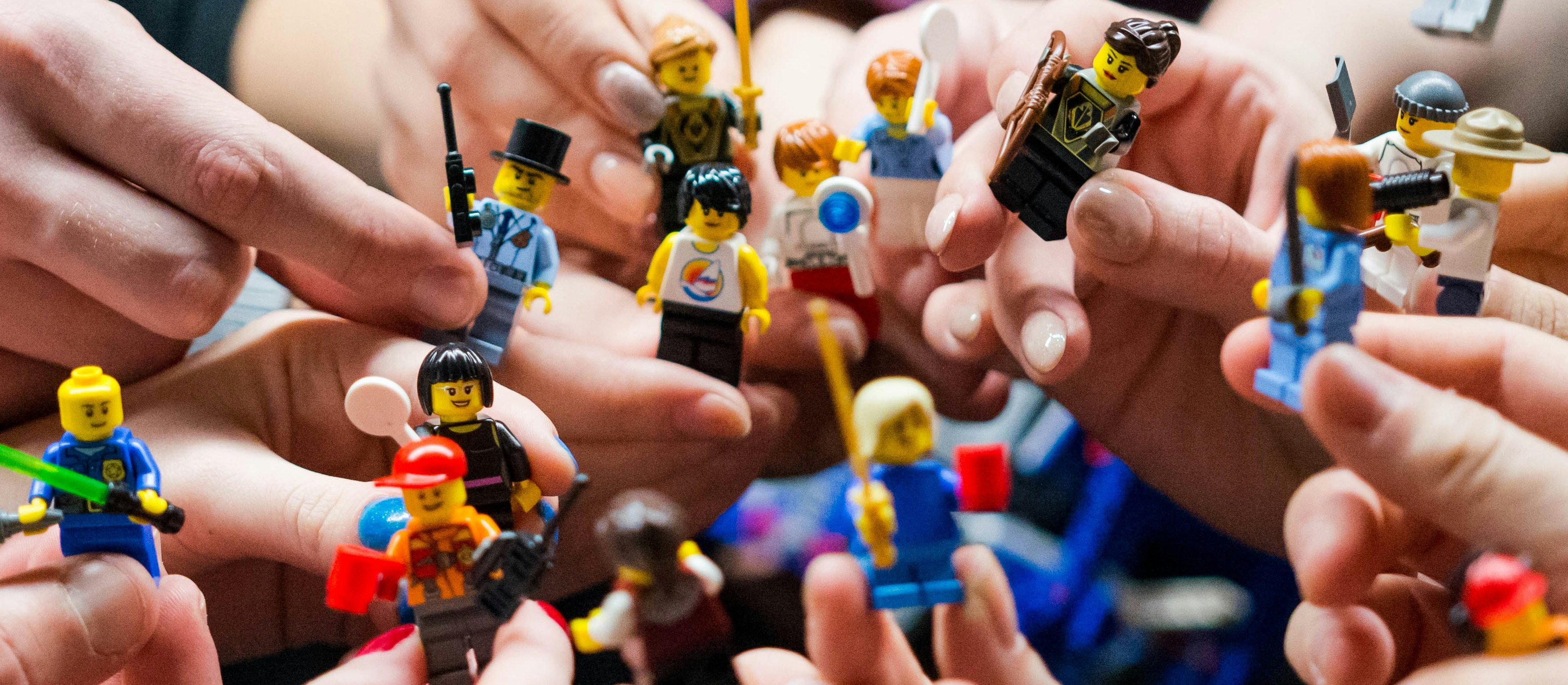 Hands hold Lego figures [Vlad Hilitanu on Unsplash]