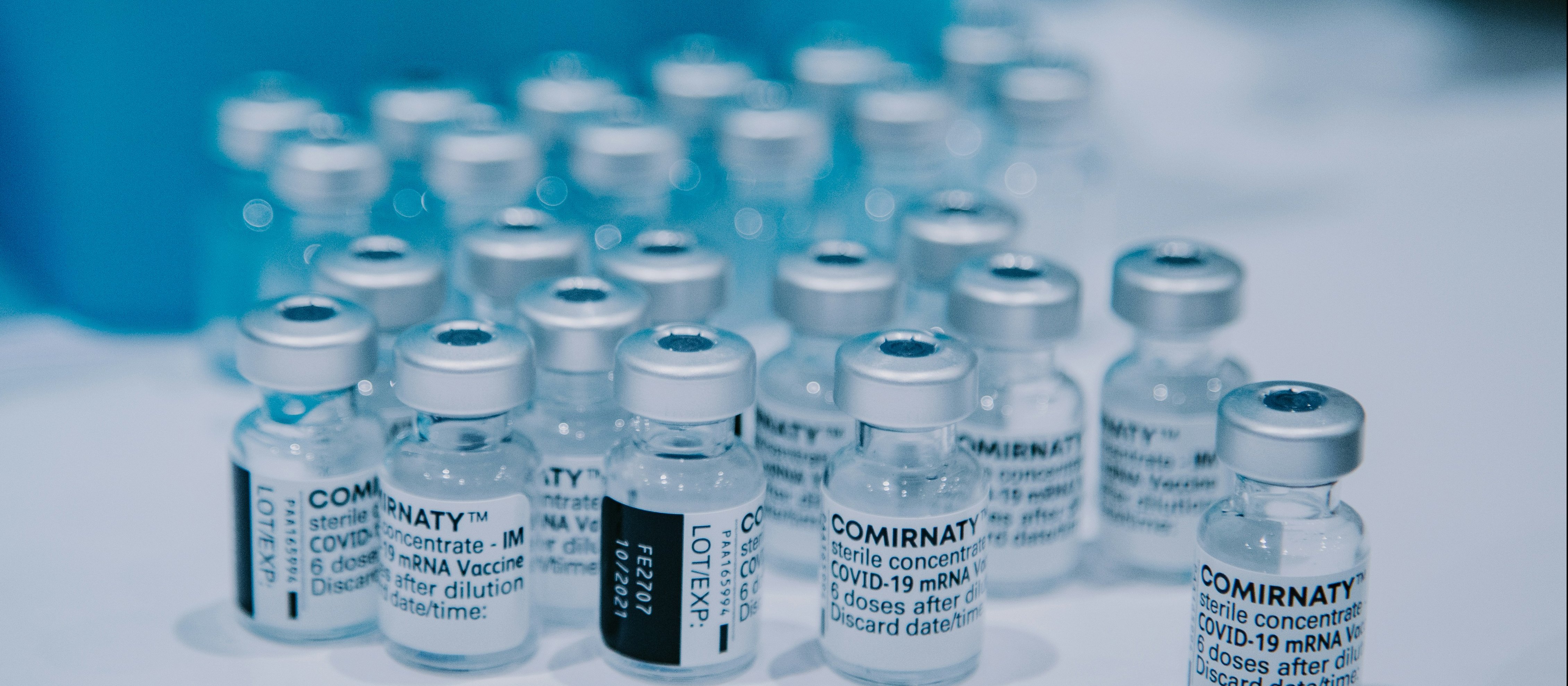 Vials of Comirnaty covid-19 vaccines sitting on a white bench