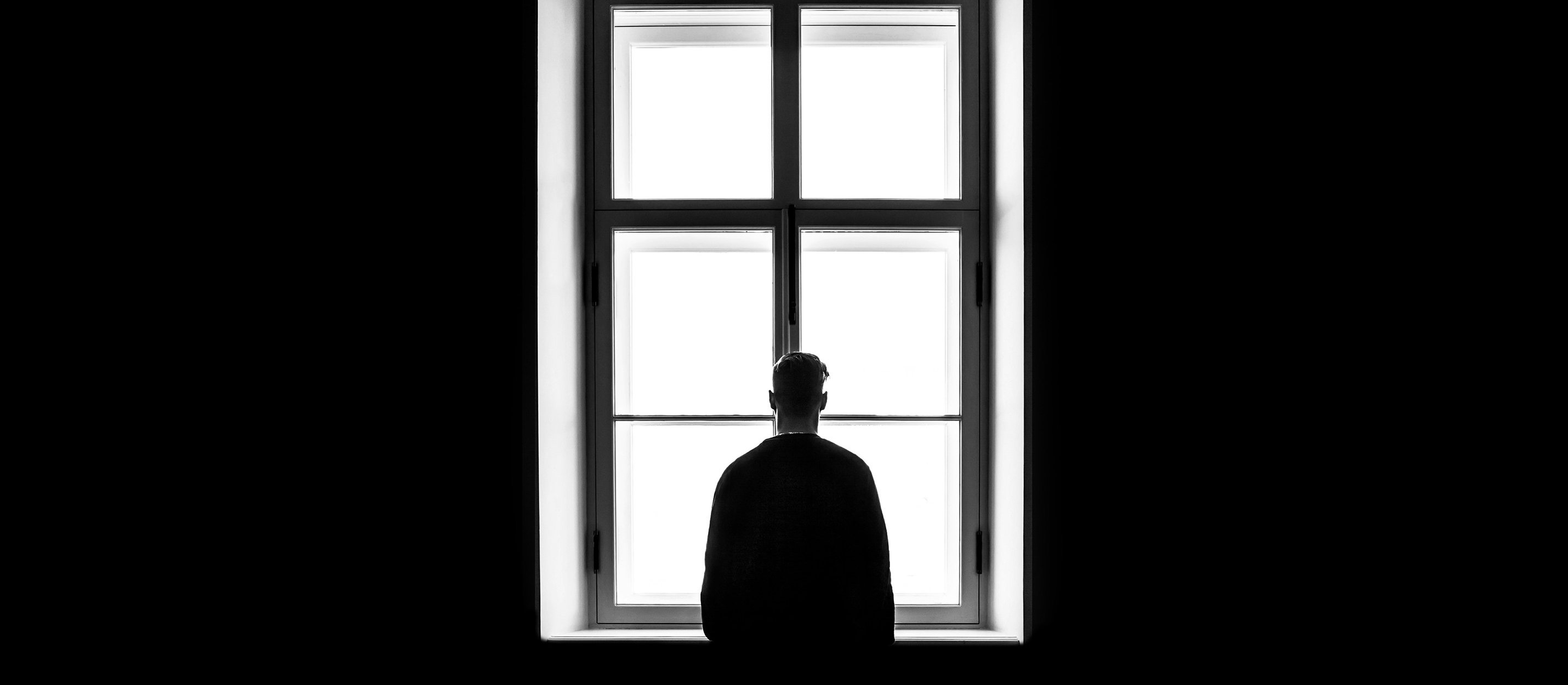 Man at window, shadows [Photo by Sasha Freemind on Unsplash]