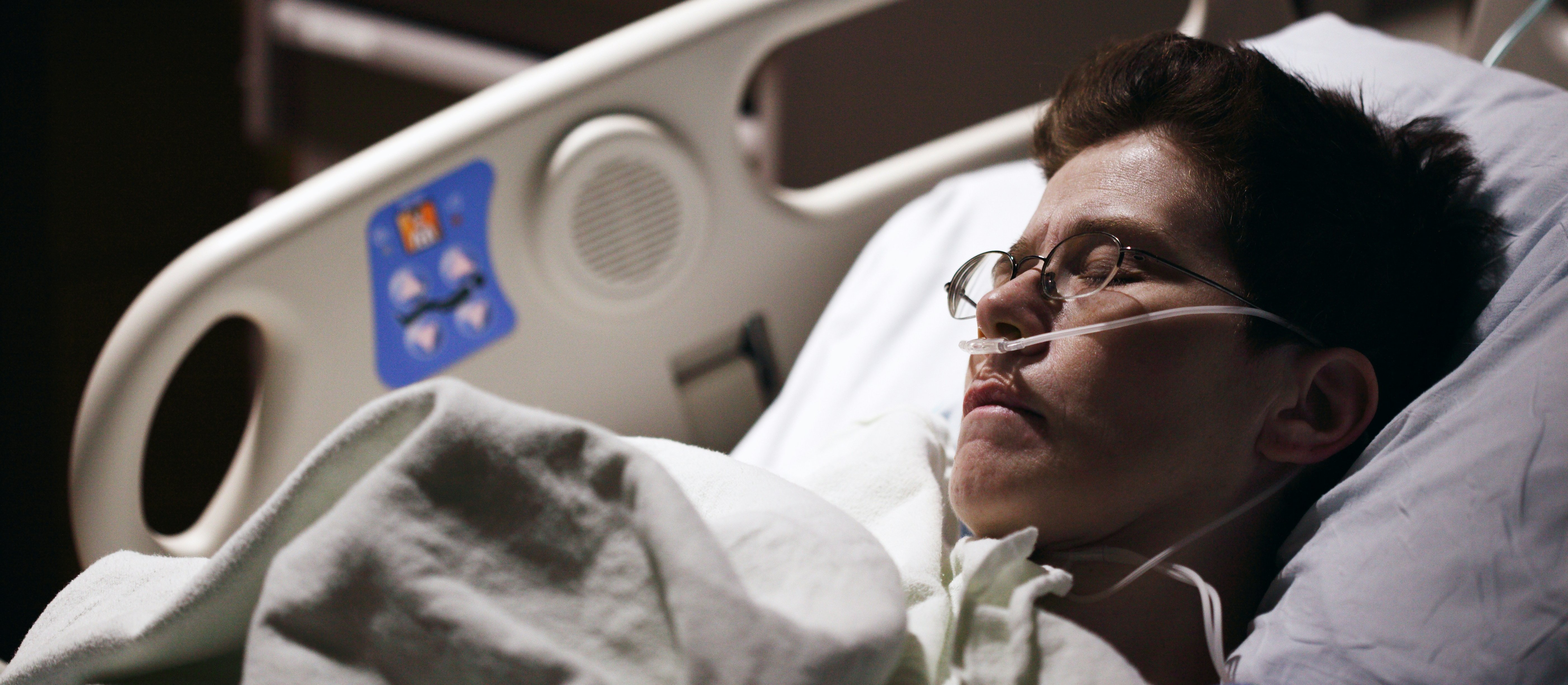 Man with glasses in hospital bed