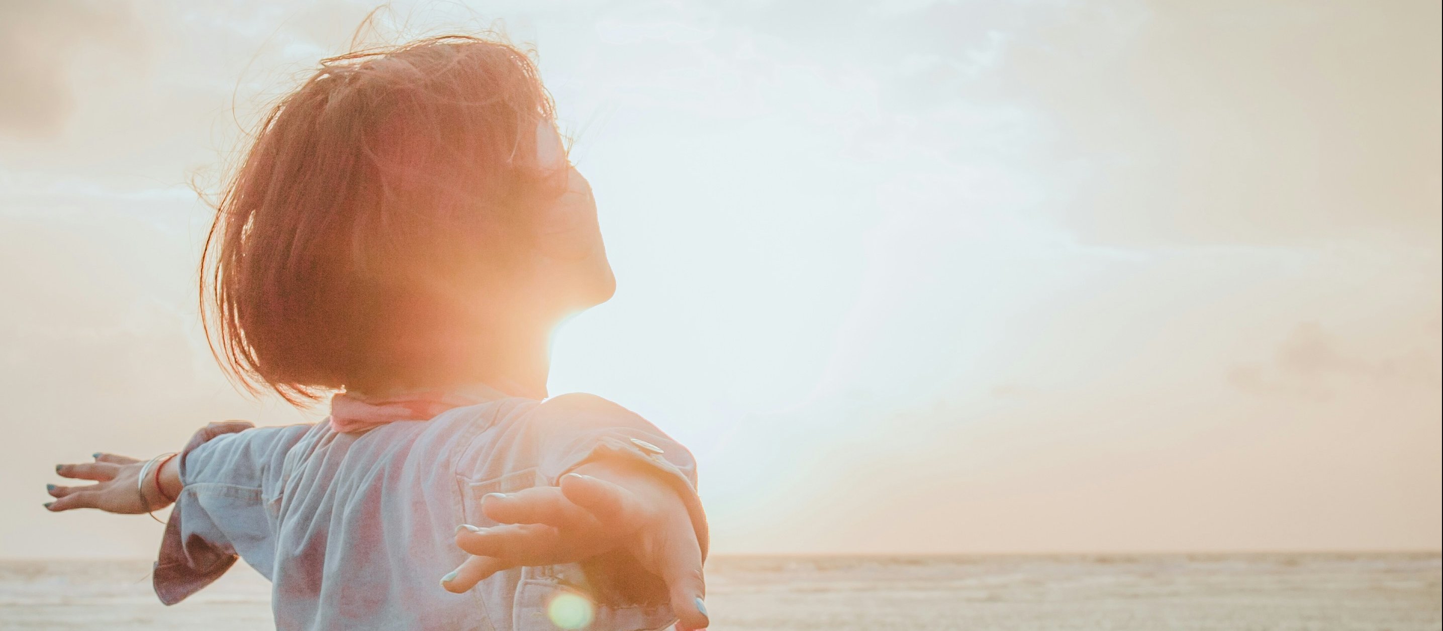 Woman, arms spread, sunshine