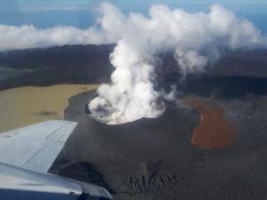 Ambae volcano and Lake Voui on 21 April 2018, Ambae Island, Vanuatu. The lake has been split into two due to the growth of the new volcanic cone. The visible landscape is covered with thick ash deposits. The dead trees in the lower right were killed over a decade ago during another eruptive episode. Photo credit: Natalia Deligne.