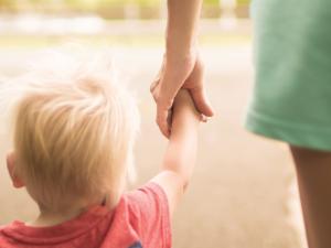 Boy holding hands with woman