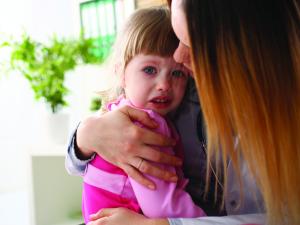 Woman holding a child, young child, sad, 