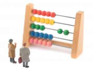 Miniature people with an abacus