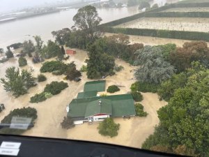 Aerial view taken from an NH90 helicopter of two people on the roof of their house to escape rising floodwaters caused by Cyclone Gabrielle