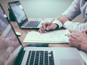 Two people working together on a project, with two laptops