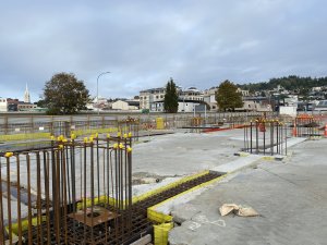 Foundation beams in various stages of construction. These link up the previously installed piles. The yellow material is leave-in-place boxing, and this retains the concrete until it hardens. In the bottom left corner the column alignment plate can be seen awaiting the columns, and these  are due to arrive in June 2023