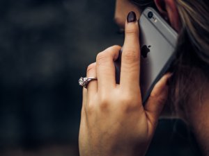 Close up of woman's hand holding an iPhone to her ear