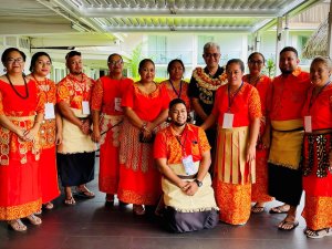 A group of people in brightly-coloured traditional dress posing for a photo