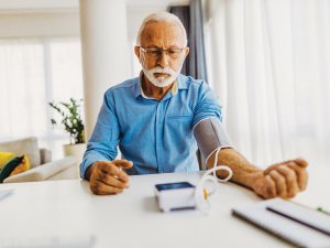 Older man measures blood pressure