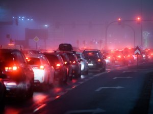 A line of cars in a traffic jam with smog haze