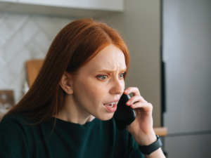 Redhead woman on phone agitated CR Dikushin on iStock