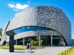 Image shows Te Pae convention centre from the outside, set against a blue sky