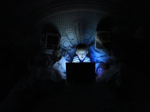 Child on bright screen in darkened room