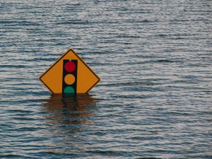 Submerged traffic sign, flooding [Kelly Sikkema on Unsplash]