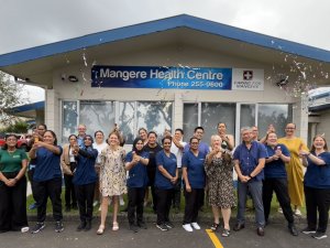 Staff stand outside Mangere Health Centre and let off party poppers