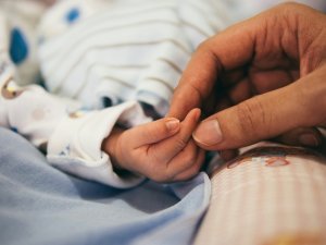 Baby and adult hand CR Aditya Romansa on Unsplash