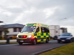 An ambulance with flashing lights appears to be driving fast to an emergency