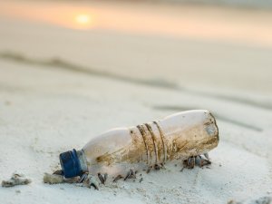 Plastic bottle on beach [Ishan @seefromthesky on Unsplash]