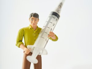 Toy man holding a syringe