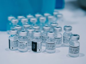 Vials of Comirnaty covid-19 vaccines sitting on a white bench