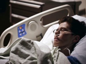 Man with glasses in hospital bed