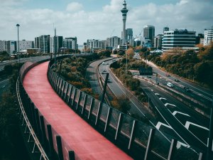 Auckland city with Skytower in the background, motorway and pink cycleway in foreground