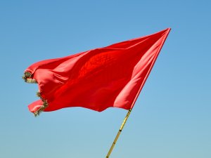 Red flag on pole daytime CR mhrezaa on Unsplash